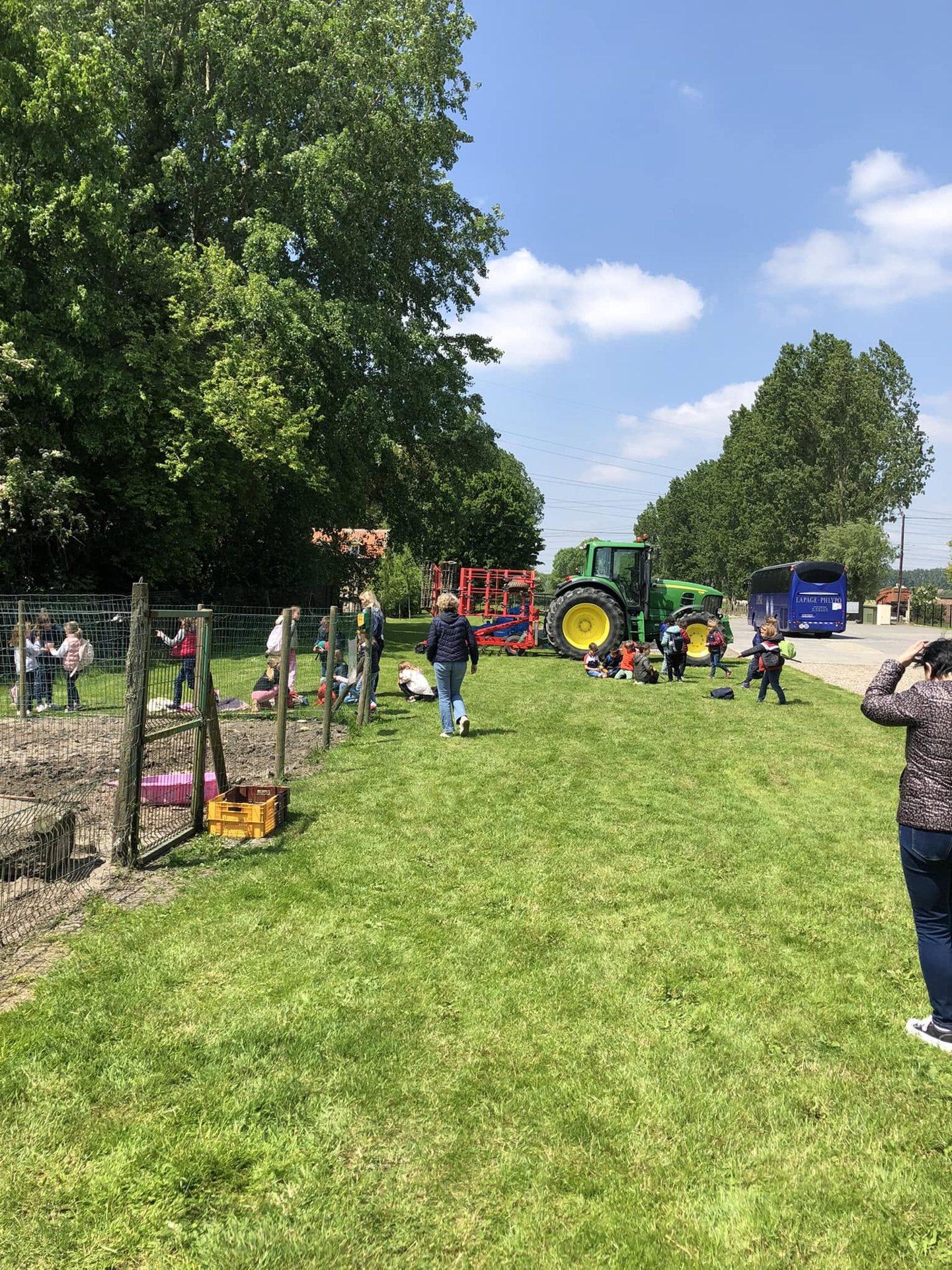Un groupe d’enfants au pied du grand tracteur vert