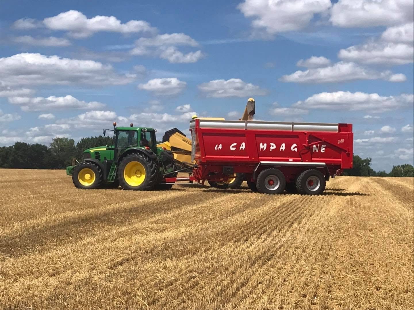 Le grain de la moisson est versé dans la benne du tracteur